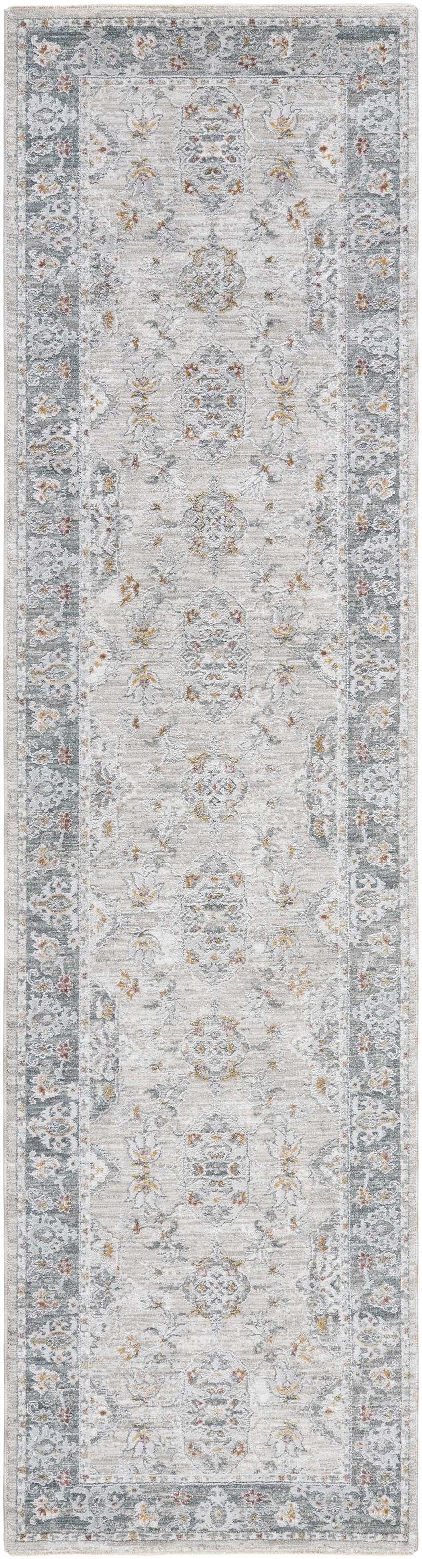 Close-up of the Greco Textured Rug with Fringes. Features a traditional, light gray floral pattern and a textured finish. Design-Runner-2710