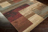 Close-up of the Sentinel Riley Geometric Rug. Features red, brown, tan, and light green geometric blocks. Corner