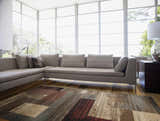Bright living room with a gray sofa and the Sentinel Riley Geometric Rug in shades of brown, red, and gray. Roomscene-Rectangle