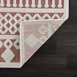 Close-up of Jove Orange Outdoor Rug showing bone and terracotta geometric pattern and machine woven construction. Fold