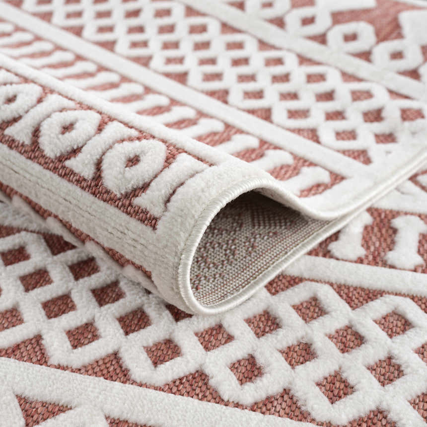Close-up of the Jove Orange Outdoor Rug showing the bone and terracotta geometric Southwestern design and woven texture. Fold