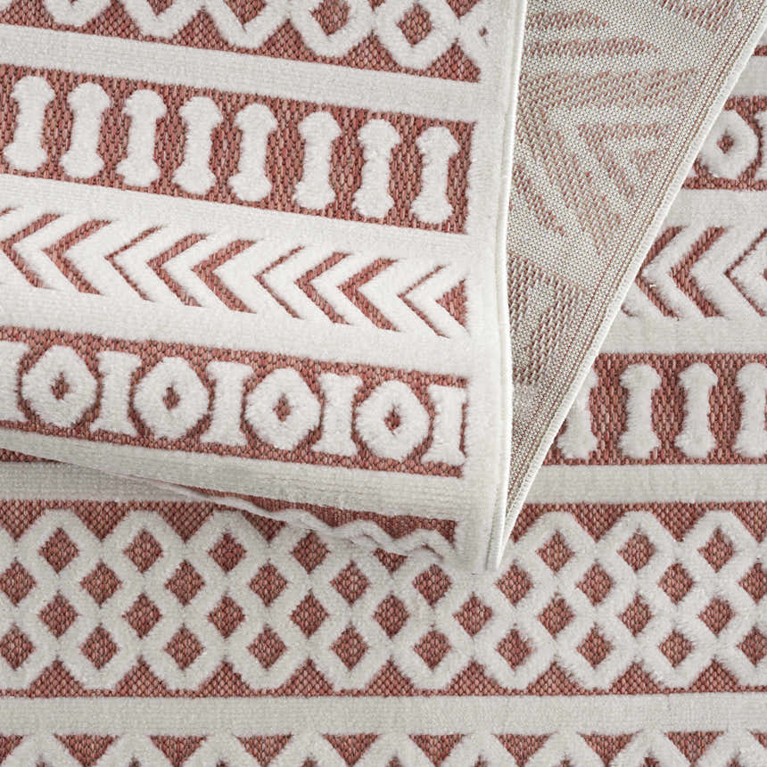 Close up of the Jove Orange Outdoor Rug showing the bone and terracotta geometric Southwestern pattern. Fold