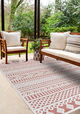 Outdoor patio scene with Jove Orange rug, wooden furniture, and lush greenery backdrop. Southwestern style. Roomscene-Rectangle