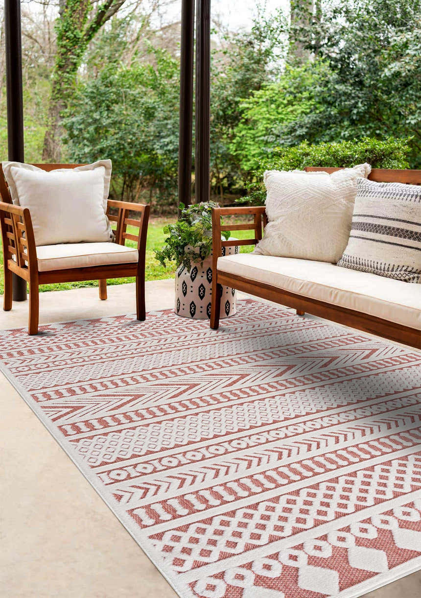 Outdoor patio scene with Jove Orange rug, wooden furniture, and lush greenery backdrop. Southwestern style. Roomscene-Rectangle