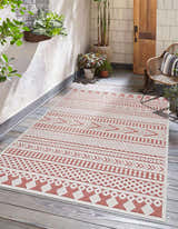 Outdoor patio scene with a Jove Orange outdoor rug, woven chair, wood door, and plants. Southwestern style. Roomscene-Rectangle