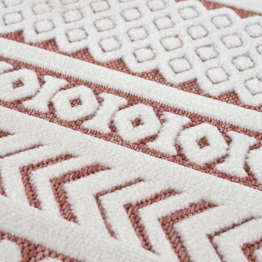 Close up of the Jove Orange Outdoor Rug showing bone and terracotta Southwestern pattern. Texture