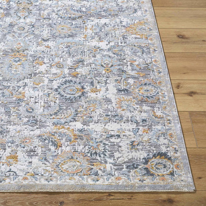 Close-up of the Atara Area Rug on hardwood floor. Gray, blue, and gold traditional pattern. Farmhouse style. Front