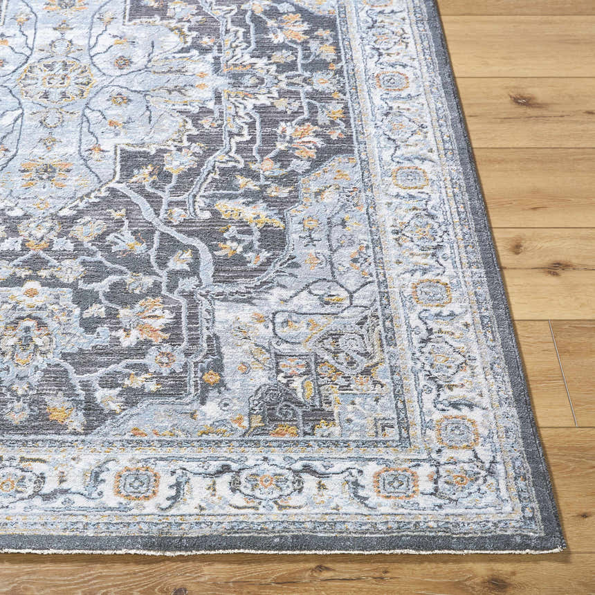 Close-up of the gray Hayfa Area Rug on wood flooring, showcasing its traditional floral pattern and soft texture. Front