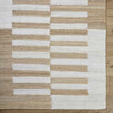 Close-up of the hand woven Soren Area Rug. Jute rug with ash, light silver, and tan horizontal stripes. Corner