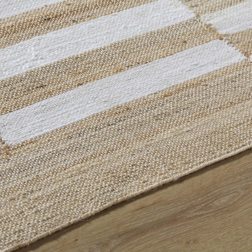 Close-up of the hand-woven Soren Area Rug. Jute rug with ash and light silver stripes and a natural, textured look. Texture