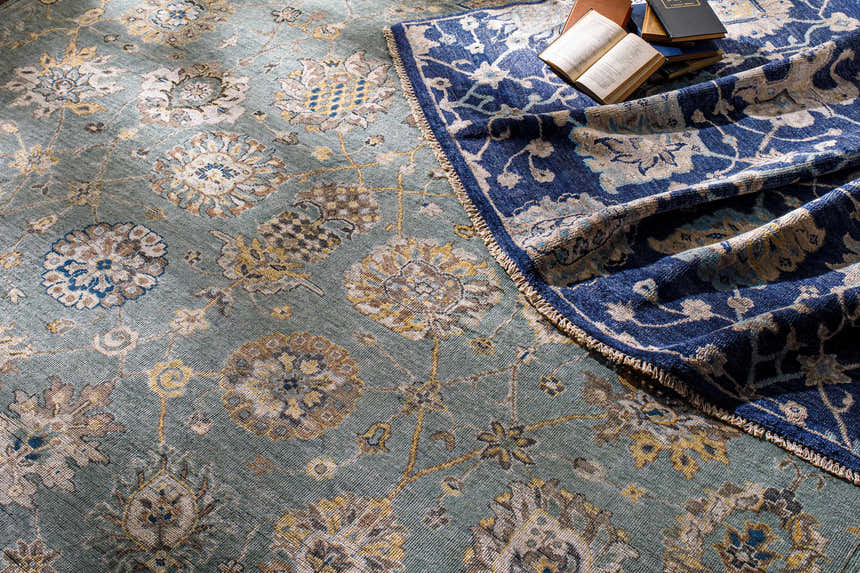 Close-up of Pinetop Premium Rug in aqua, charcoal, and gold with a floral pattern and hand-knotted texture. Styleshot