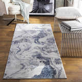 Living room scene with a Moana Denim Blue Marble Area Rug, cream chair, and metal bench. Roomscene-Runner