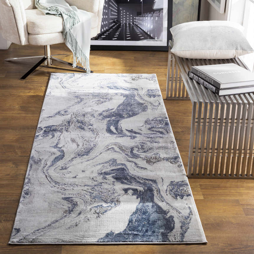 Living room scene with a Moana Denim Blue Marble Area Rug, cream chair, and metal bench. Roomscene-Runner