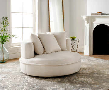 Living room scene with a cream round chair on the Aramawayan Premium Hand Knotted Wool Area Rug in charcoal, cream and ice blue. Roomscene-Rectangle
