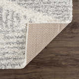Close up of the Trunding Plush Area Rug in Gray, showing the shag texture and backing. Fold