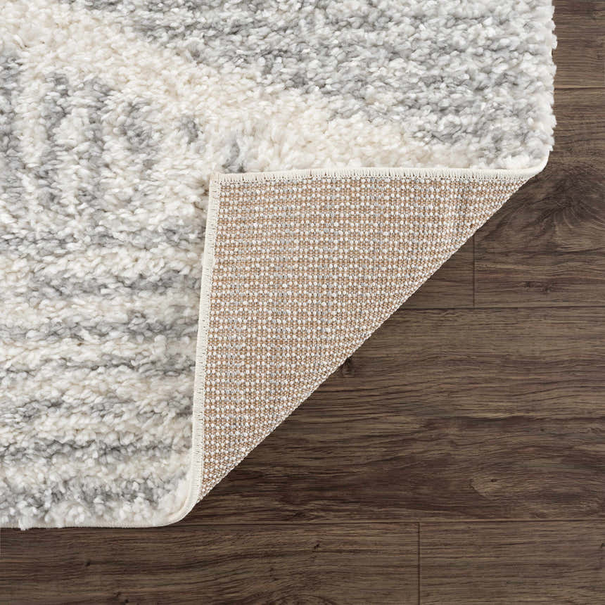Close up of the Trunding Plush Area Rug in Gray, showing the shag texture and backing. Fold