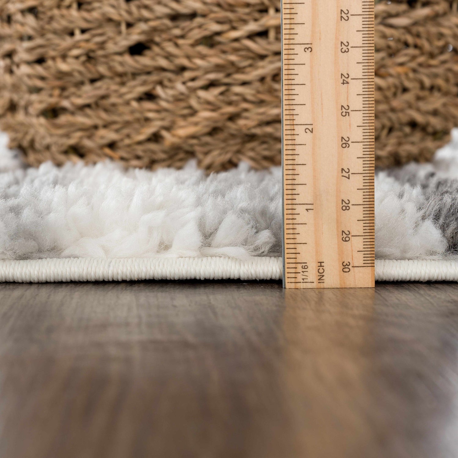 Close-up of the Zoya Irregular Striped Area Rug showing the shag texture, beige, cream, and gray stripes, and rug thickness. Pile
