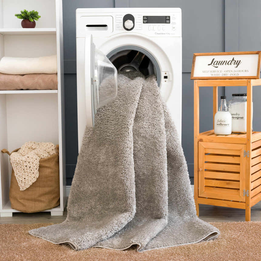 Laundry room scene with a light gray Judy Solid Washable Shag Rug coming out of the washing machine. Washing-Machine