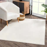Living room scene with a Judy White Washable Area Rug, fluffy white chair, wood cabinet, and dark wood floors. Roomscene-Rectangle