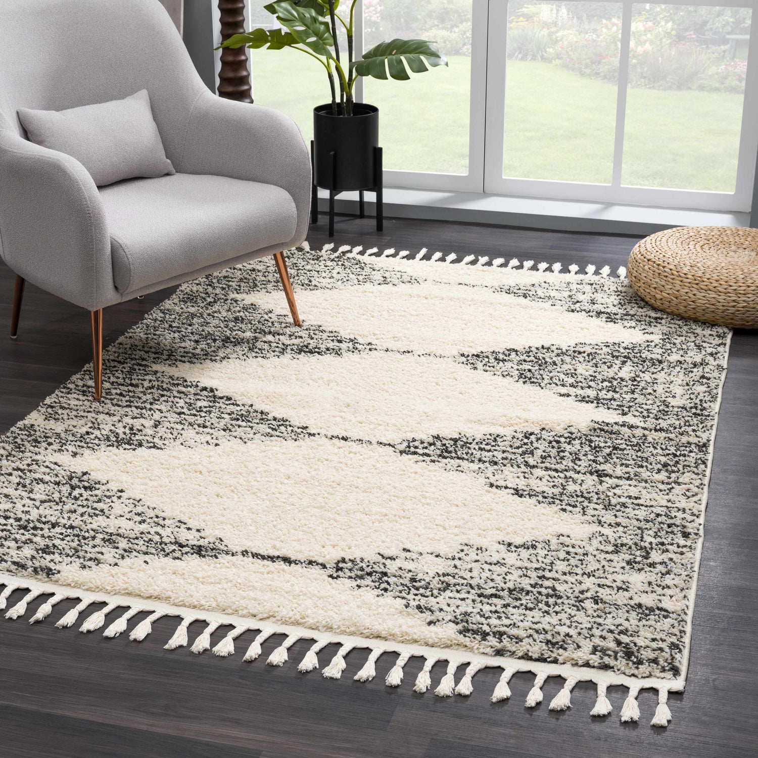 Living room scene with a gray chair and the bone and dark gray Howth Area Rug with tassels. Roomscene-Rectangle