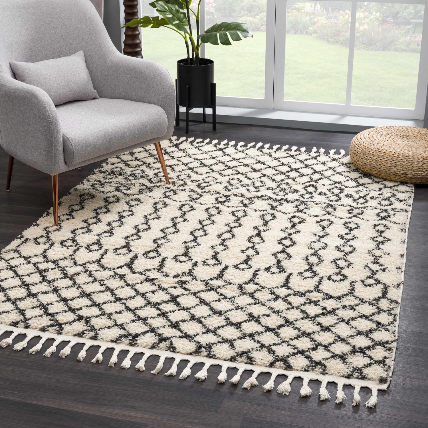 Living room scene with a charcoal and light beige Muni Berber Shag Rug, gray chair, and woven ottoman. Roomscene-Rectangle