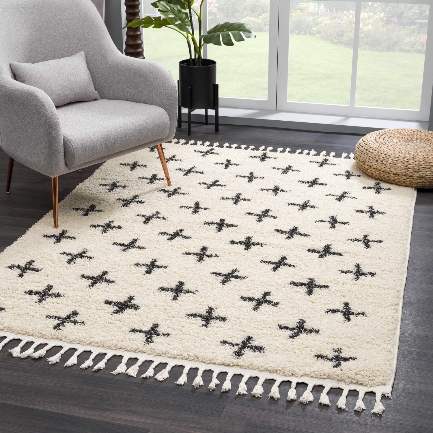 Living room scene with a beige Alstead Shag Area Rug featuring a black plus sign pattern and white tassels. Roomscene-Rectangle