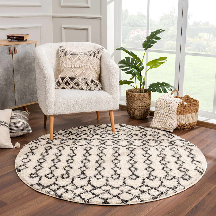 Cozy living room scene with round Muni Berber Shag Rug, white armchair, and natural light. Bohemian, farmhouse style. Roomscene-Round