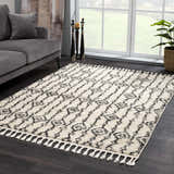 Living room scene with a gray sofa and the Bayanga rug in charcoal and cream with a Moroccan shag design. Roomscene-Rectangle