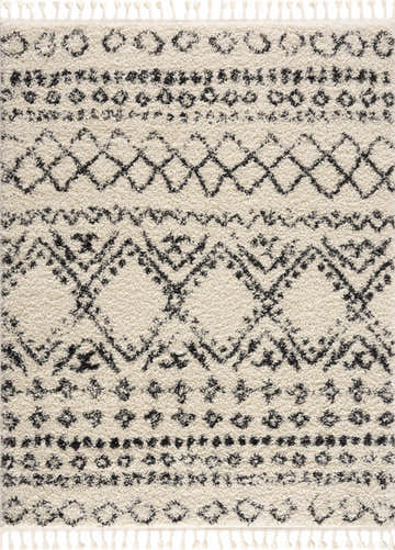 Close-up of the Duncans Area Rug. Bone shag rug with a multi-brown Moroccan-inspired geometric pattern and tassels. Design-Rectangle