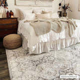 Bohemian bedroom with a white bed, wood dresser, and beige Minoa Area Rug. Neutral, cozy aesthetic. Roomscene-Rectangle