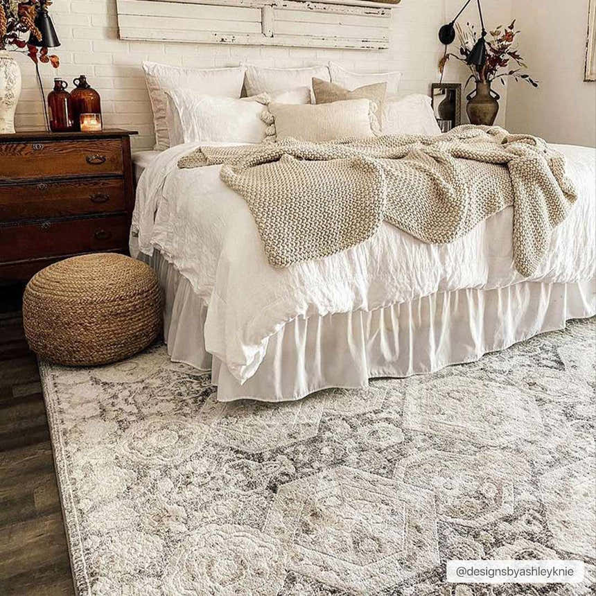 Bohemian bedroom with a white bed, wood dresser, and beige Minoa Area Rug. Neutral, cozy aesthetic. Roomscene-Rectangle