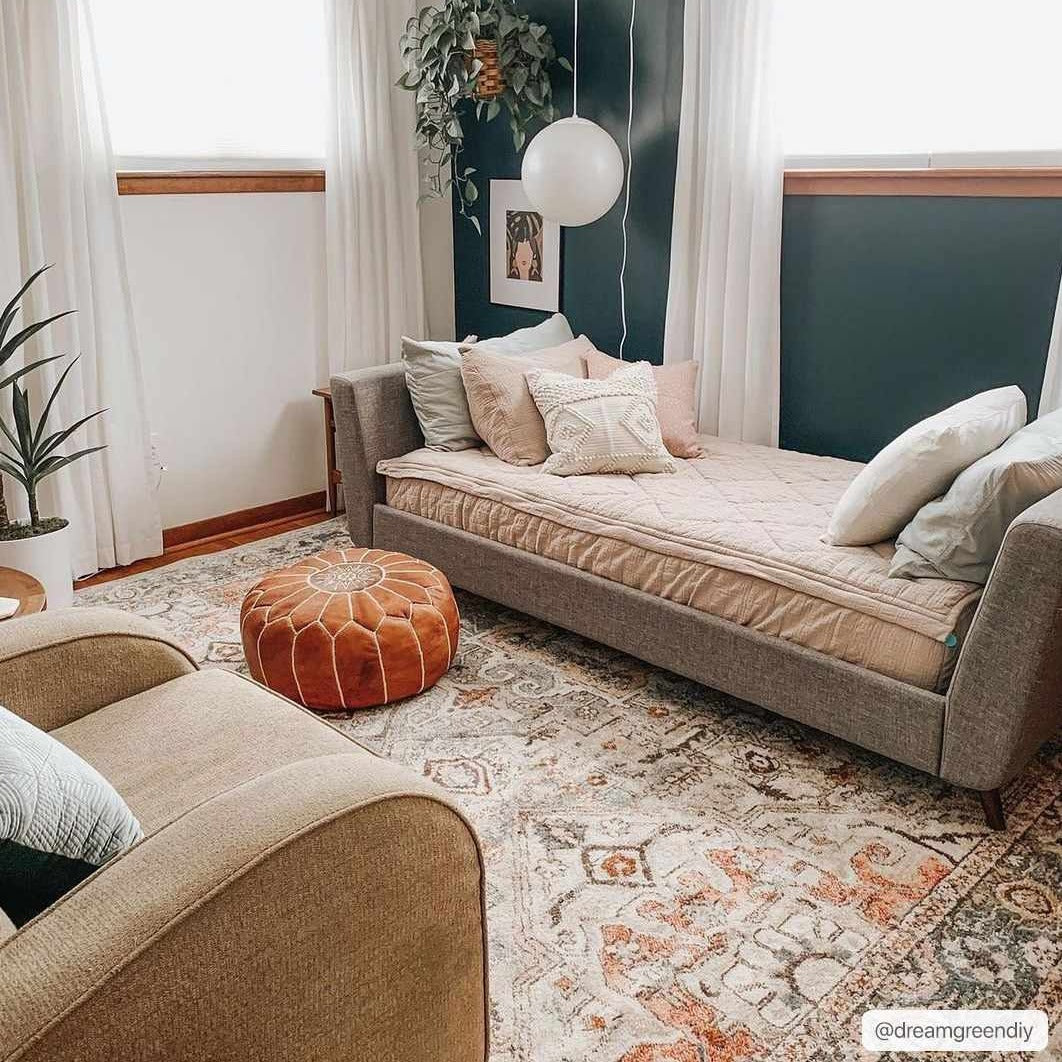 Cozy living room scene with a brick red and camel Bolinas Area Rug, daybed, tan chair, and leather pouf. Roomscene-Rectangle