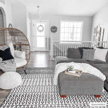 Gray living room with a Constantin Area Rug, gray couch, egg chair, and white accents. Roomscene-Rectangle