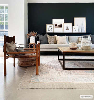 Living room with a Baloy Vintage Washable Rug, wood chair, gray sofa, and black accent wall. Bohemian, farmhouse style. Roomscene-Rectangle
