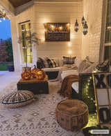 Fall porch scene with Mirani 3D Outdoor Area Rug, pumpkins, cozy seating, and string lights. Charcoal and light beige rug. Roomscene-Rectangle