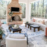 Covered patio with brick fireplace, white sofas, and blue Dorval Traditional Rug. Roomscene-Rectangle