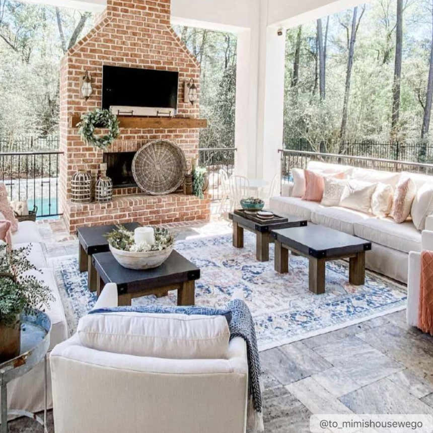 Covered patio with brick fireplace, white sofas, and blue Dorval Traditional Rug. Roomscene-Rectangle