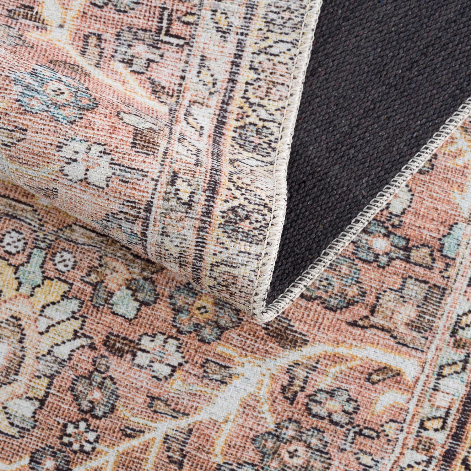 Close-up of the Flat Pile Urpi Red Washable Rug, showing its traditional Persian pattern, red hues, and durable gray backing. Fold