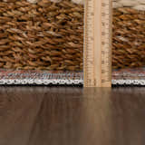 Close-up of Urpi Rose & Blue Washable Area Rug showing rug thickness with ruler, woven edge, and polyester material. Pile