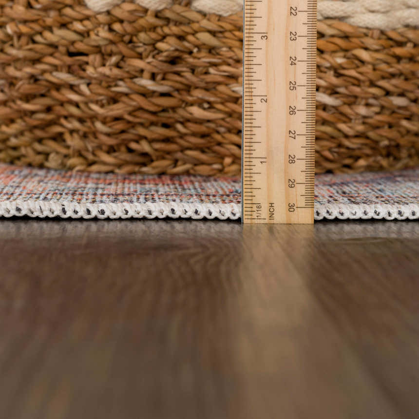 Close-up of Konstantina Washable Area Rug showing rug thickness with ruler. Features traditional Persian design and fringe. Pile