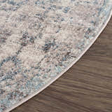 Close-up of the Orrick Area Rug showing its blue, cream, and brown tones, plus soft texture and machine-woven construction. Corner