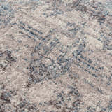 Close-up of the Orrick Area Rug showing its cream, light gray, and blue abstract pattern and soft, textured weave. Texture