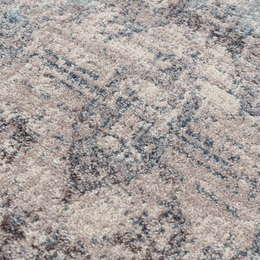 Close-up of the Orrick Area Rug showing its cream, light gray, and blue abstract pattern and soft, textured weave. Texture