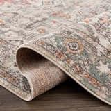 Close-up of the Bolinas Area Rug showing its brick red, camel, and light gray traditional pattern and machine-woven texture. Fold
