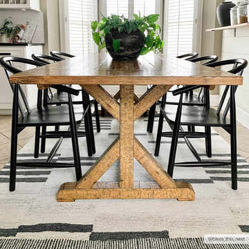 Farmhouse dining room with wood table, black chairs, and Aibonito Hand Tufted Wool Area Rug in a geometric black and beige pattern. Roomscene-Rectangle