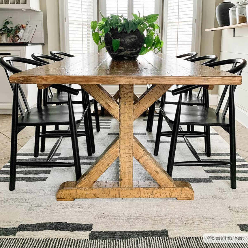 Farmhouse dining room with wood table, black chairs, and Aibonito Hand Tufted Wool Area Rug in a geometric black and beige pattern. Roomscene-Rectangle