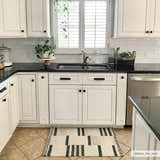 Farmhouse kitchen with white cabinets and black counters, featuring the Aibonito Hand Tufted Wool Area Rug. Roomscene-Rectangle