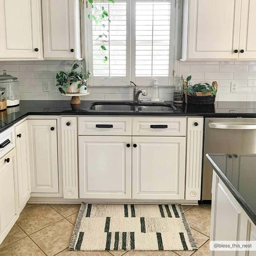 Farmhouse kitchen with white cabinets and black counters, featuring the Aibonito Hand Tufted Wool Area Rug. Roomscene-Rectangle
