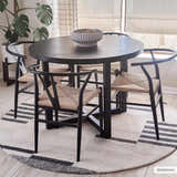 Dining room featuring a round, black table and chairs on the beige Aibonito Hand Tufted Wool Area Rug. Roomscene-Round
