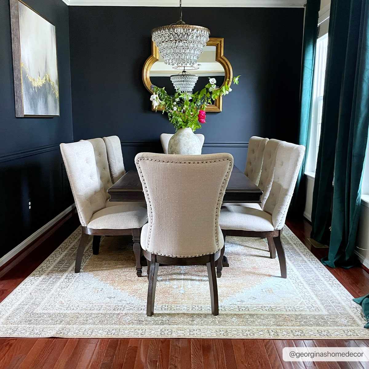 Dining room with dark walls, chandelier, and Albas Washable Area Rug in light brown and blue under a dark wood table. Roomscene-Rectangle